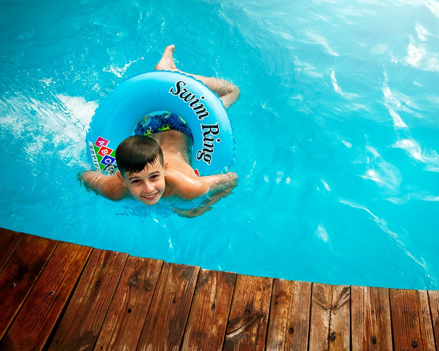niño nadando en piscina de madera